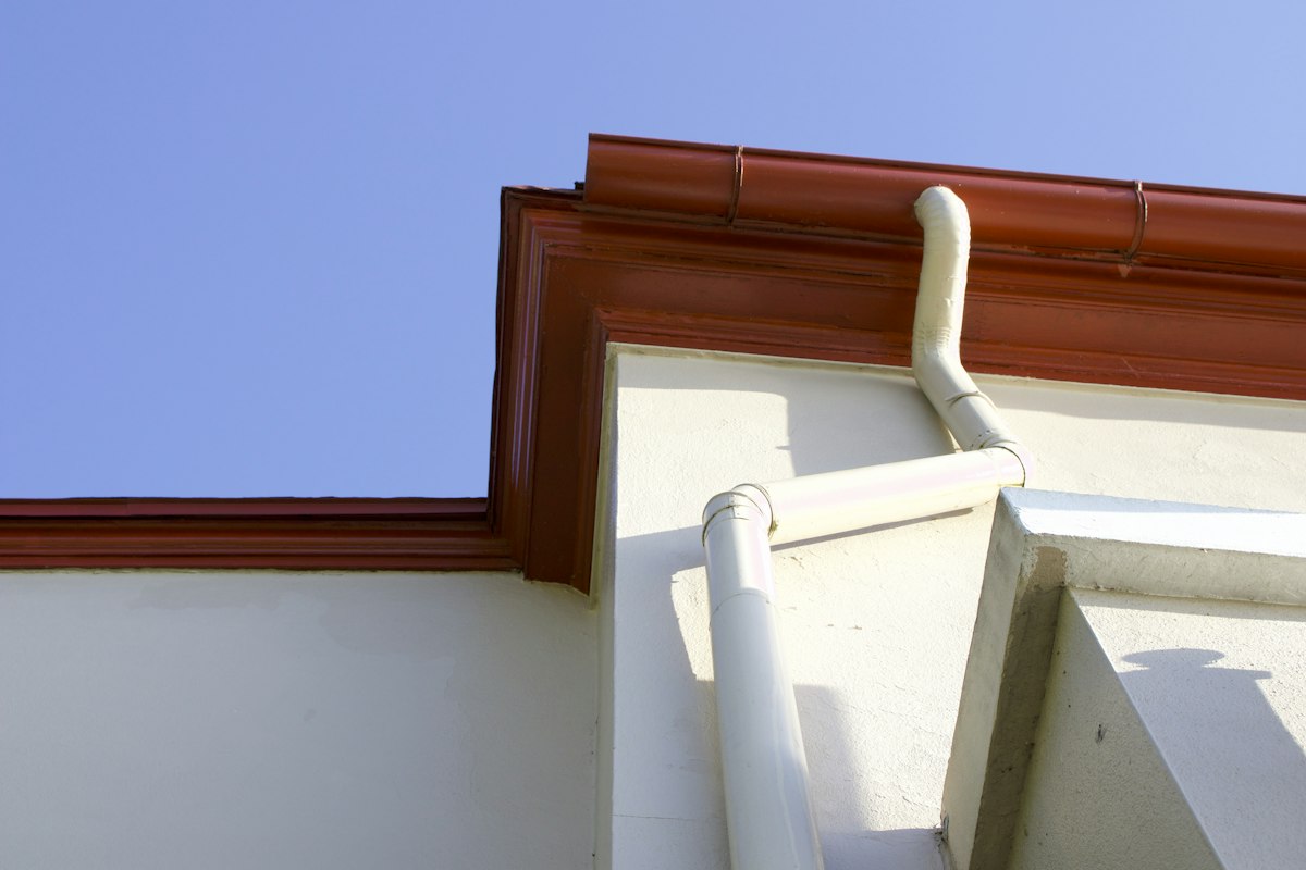 Rain gutter and downspout at a building roofline