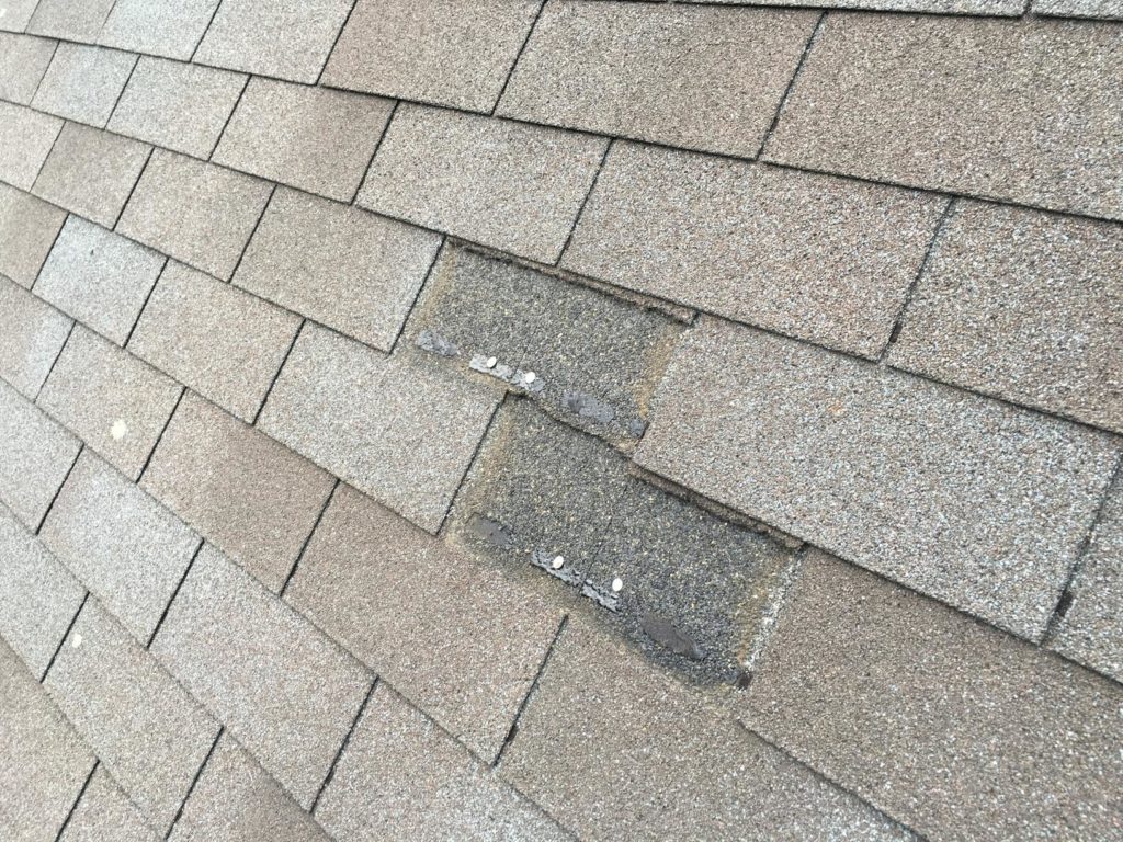2 missing shingles on an asphalt roof.